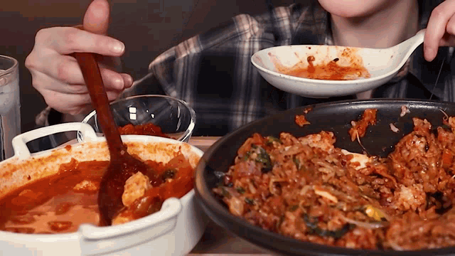 a person is eating food from a bowl with a spoon