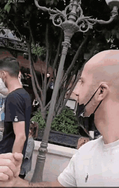 a man wearing a mask is standing in front of a lamp post