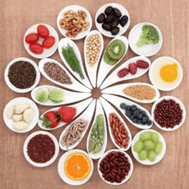 a variety of fruits and vegetables are arranged in a circle on a wooden table