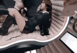 a woman in a plaid sweater is laying on a couch .