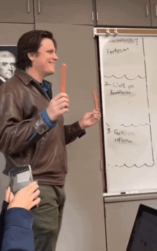 a man stands in front of a white board that says fortune on it