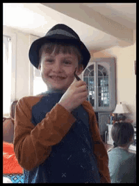 a young boy wearing a hat and a shirt with x on it