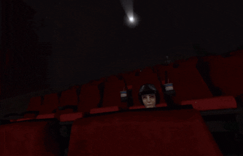 a man sitting in a movie theater with the words " i win !!! " on the screen