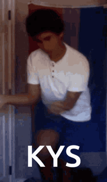a man in a white shirt is holding his stomach and the word kys is on the bottom of the image