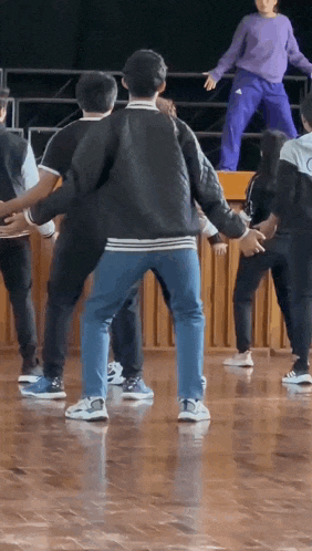a group of people are dancing together on a wood floor