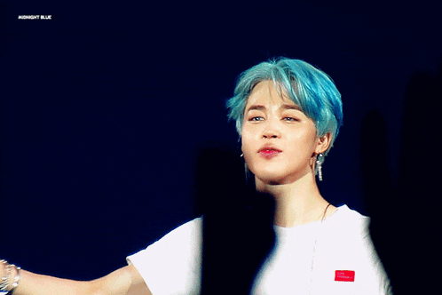 a man with blue hair is wearing a white t-shirt