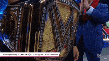 a man in a suit is holding a wrestling championship belt that says ' undisputed ' on it