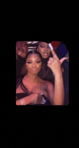 a group of women are posing for a picture and one of them is giving the middle finger
