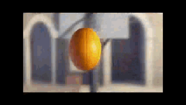 a basketball is hanging from a pole in front of a building with arches