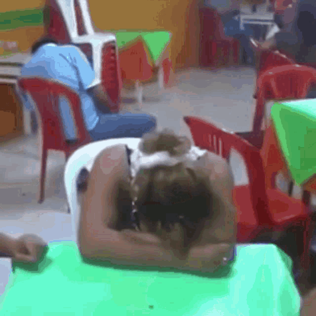 a blurry picture of a woman sleeping on a green table cloth