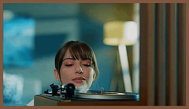 a woman playing a record on a record player