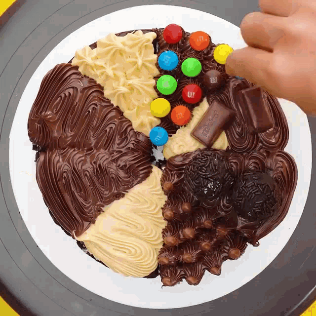 a chocolate cake with m & m 's and a kitkat bar on top