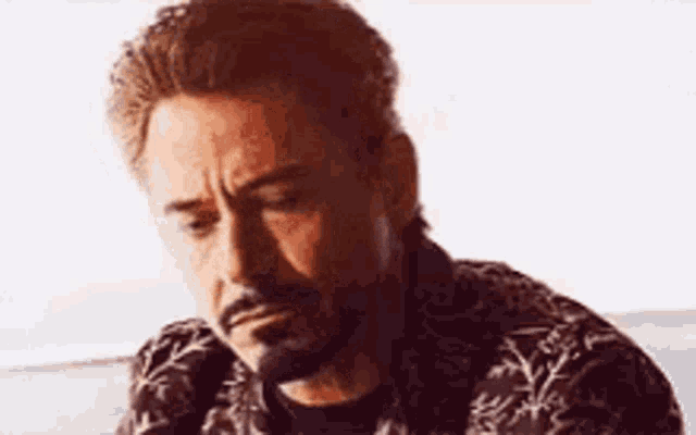 a close up of a man with a beard wearing a shirt .
