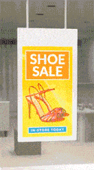a shoe sale sign hangs from the ceiling in a store window