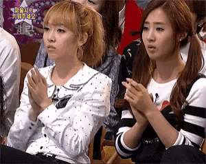 two girls are clapping their hands in front of a sign that says ' star '