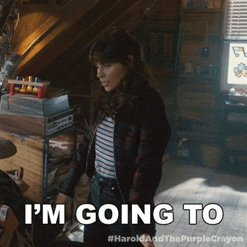 a woman says i 'm going to while standing in a room