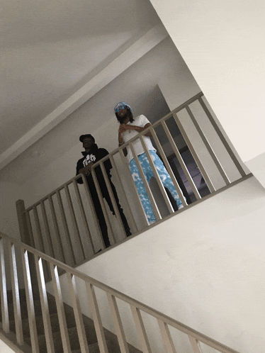 two men standing on a staircase with one wearing a shirt that says a.p.d.