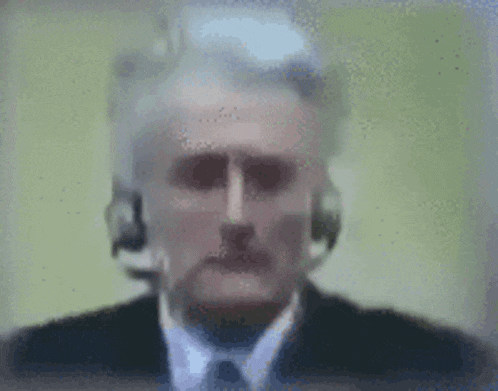 a blurry picture of a man wearing headphones and a suit