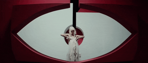 a woman in a white dress is standing in front of an eye
