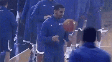 a group of basketball players are on a court and one of them is wearing a kentucky jersey