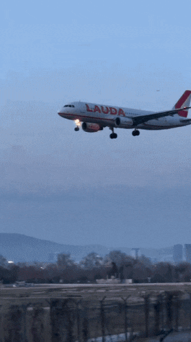 a lauda plane is taking off from an airport runway