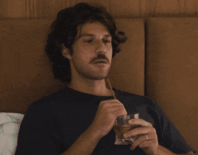 a man with a mustache is holding a glass and a straw