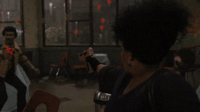a person holding a red nerf gun in a dark room