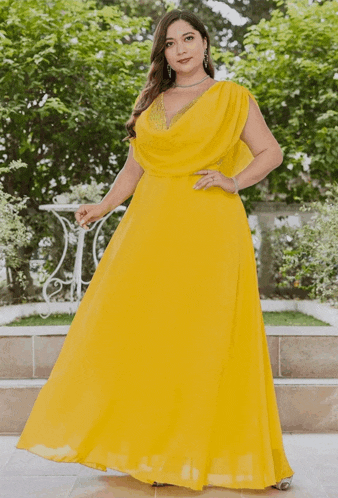 a woman is wearing a yellow dress with a plunging neckline