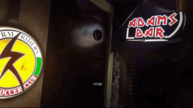 a sign for adam 's bar is lit up in the dark
