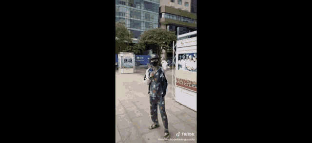 a person wearing a mask and holding a purse is walking down a sidewalk .