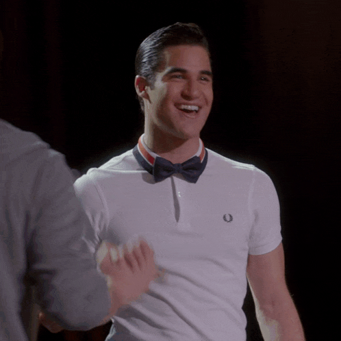 a man wearing a white shirt and a bow tie is smiling