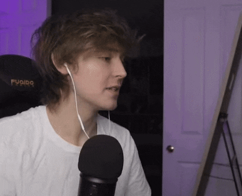 a man wearing headphones is talking into a microphone .