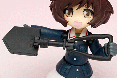 a figurine of a girl with brown hair is holding a black object