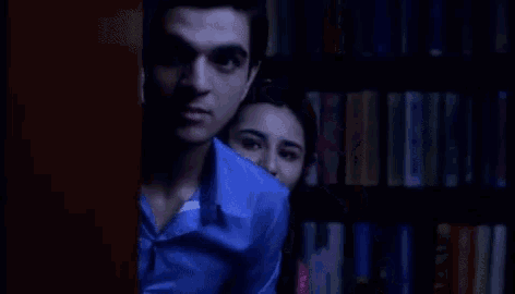 a man and a woman are hugging each other in a dark room .