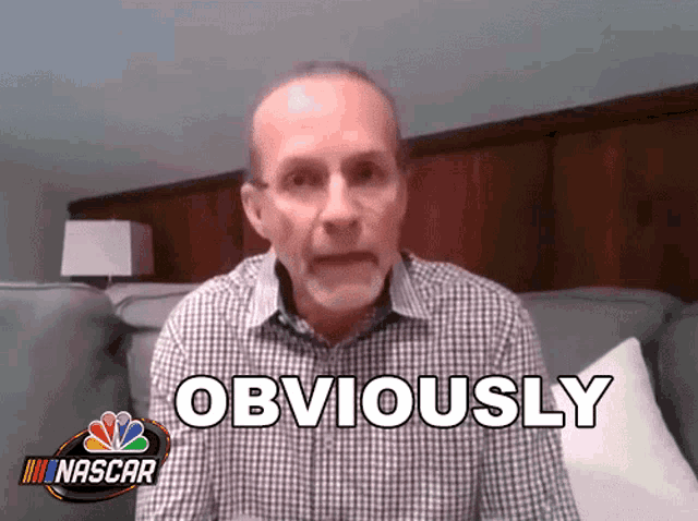 a man sitting on a couch with a nascar logo on the bottom