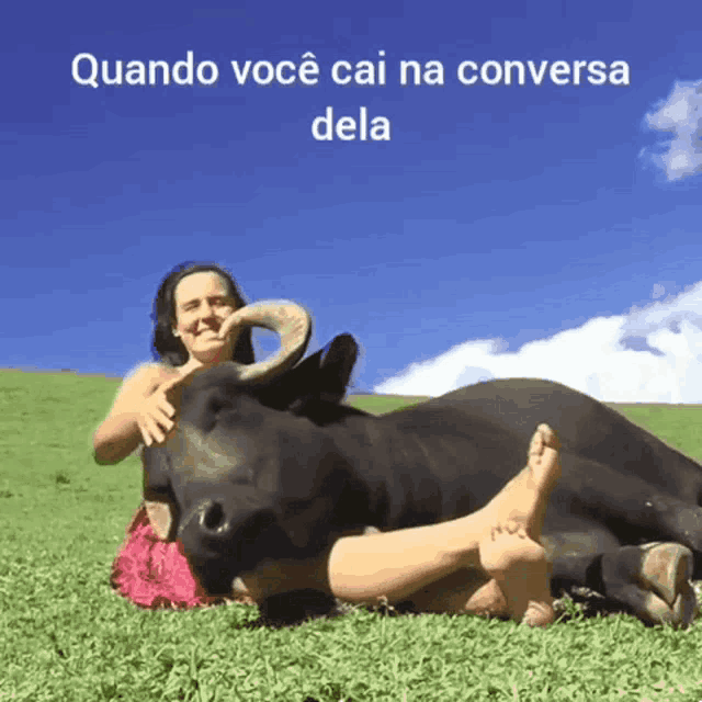 a woman laying on the grass with a bull and the words quando você cai na conversa dela above her