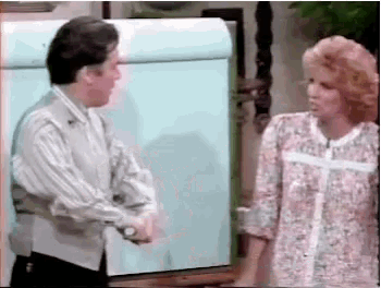 a man and a woman are shaking hands in front of a whiteboard .