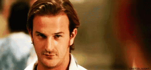 a man in a white shirt is looking at the camera .