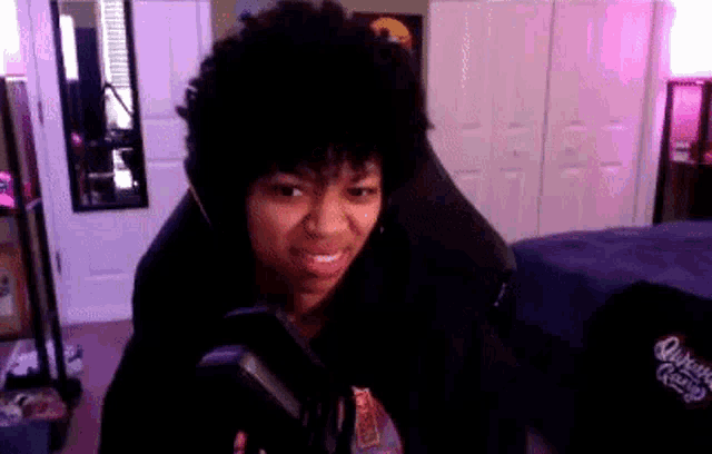 a woman is sitting in a chair with headphones on and smiling while looking at the camera .