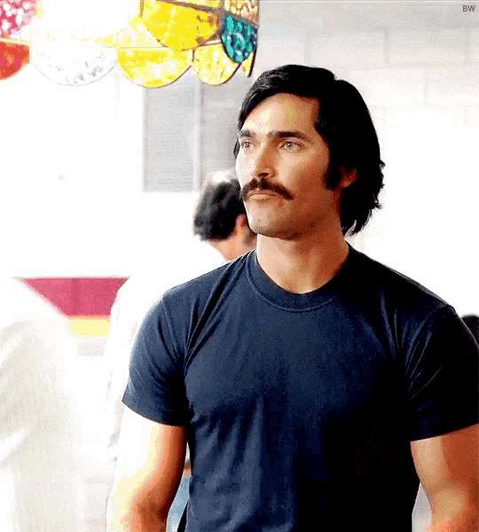 a man with a mustache wearing a black shirt