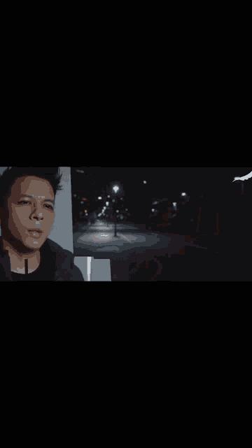 a man in a black jacket is standing in the dark