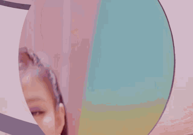 a woman with long nails is looking at herself in a mirror and smiling .