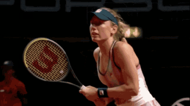 a woman is holding a tennis racquet that says wilson on it
