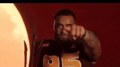 a man wearing a jersey with the number 55 on it points at the camera