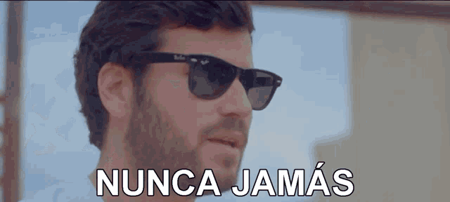 a man wearing sunglasses says " nunca jamas " in white letters