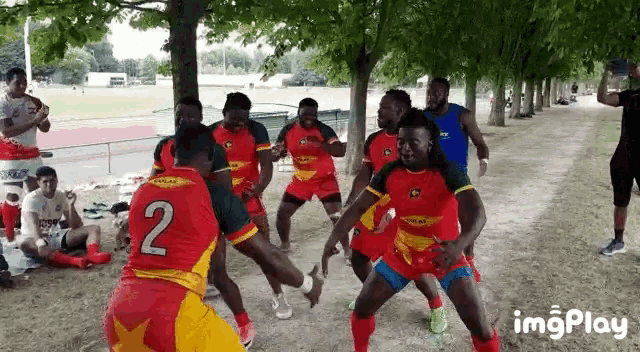 a group of men are playing rugby and one of them has the number 2 on his shirt