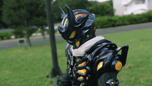 a man in a black costume with horns is standing in a park