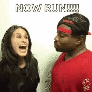 a man and a woman are standing next to each other and the man is wearing a red shirt and hat .