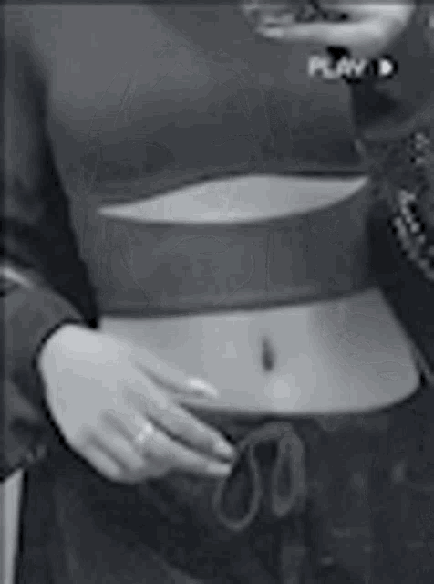 a black and white photo of a woman 's stomach and a crop top .