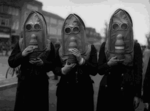 a group of people wearing gas masks are standing in a line